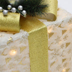 3er-Set LED-Geschenkboxen – Weihnachtsdeko mit Schneeflocken- und Tannenmuster, verziert mit goldenen Schleifen, Zweigen & silbernen Beeren